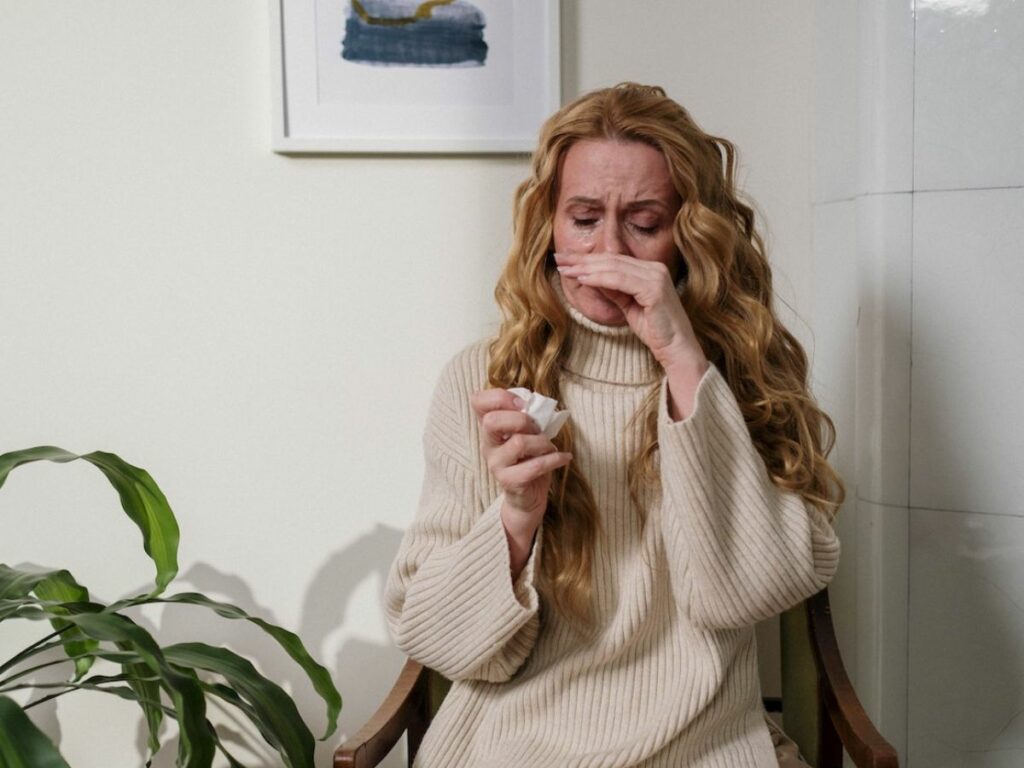 A woman with allergies trying to clean her nose