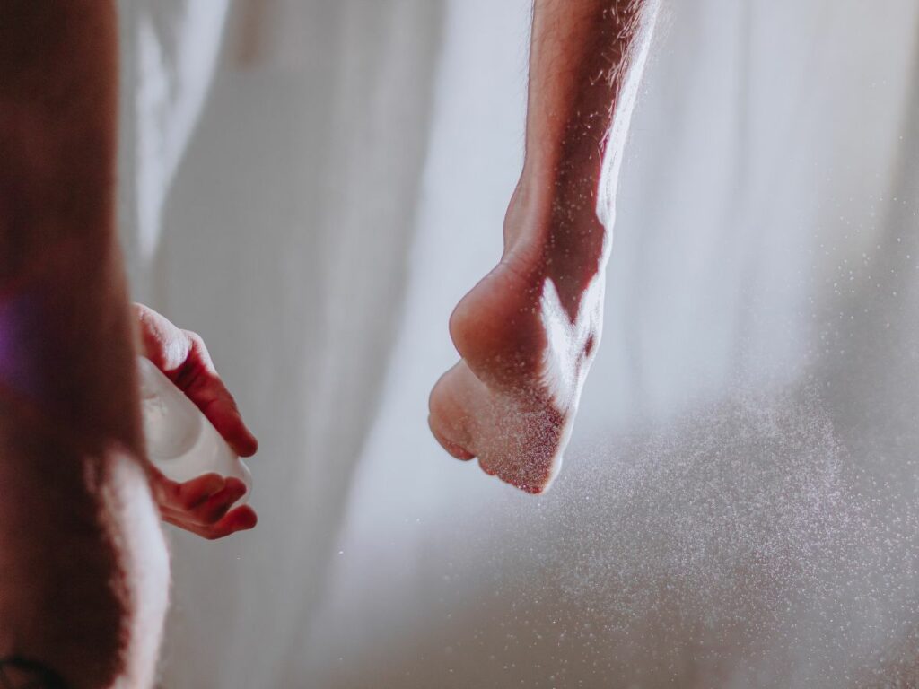 A man using foot deodorant on his feet