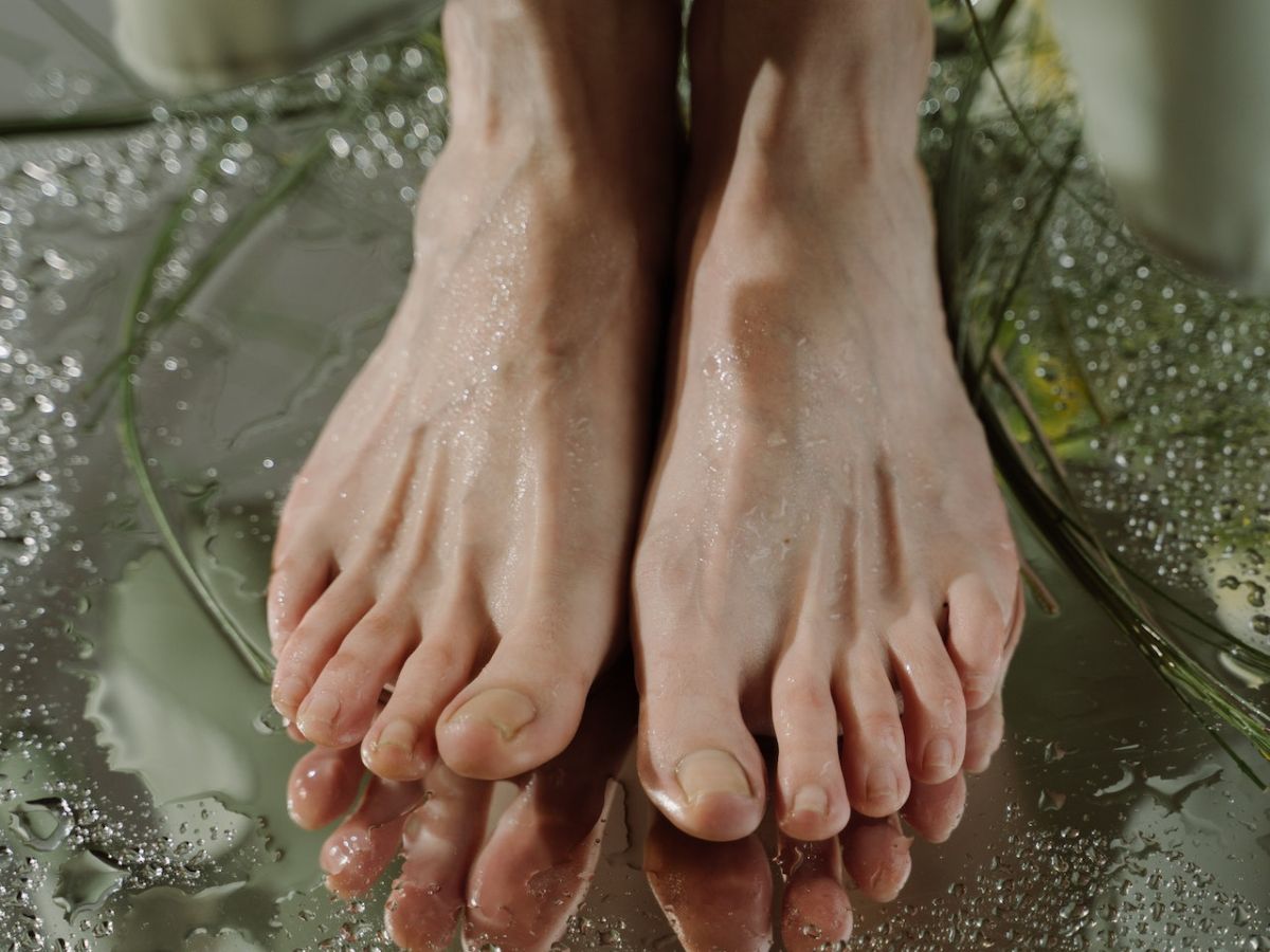 Pair of sweaty feet on a mirror-like surface